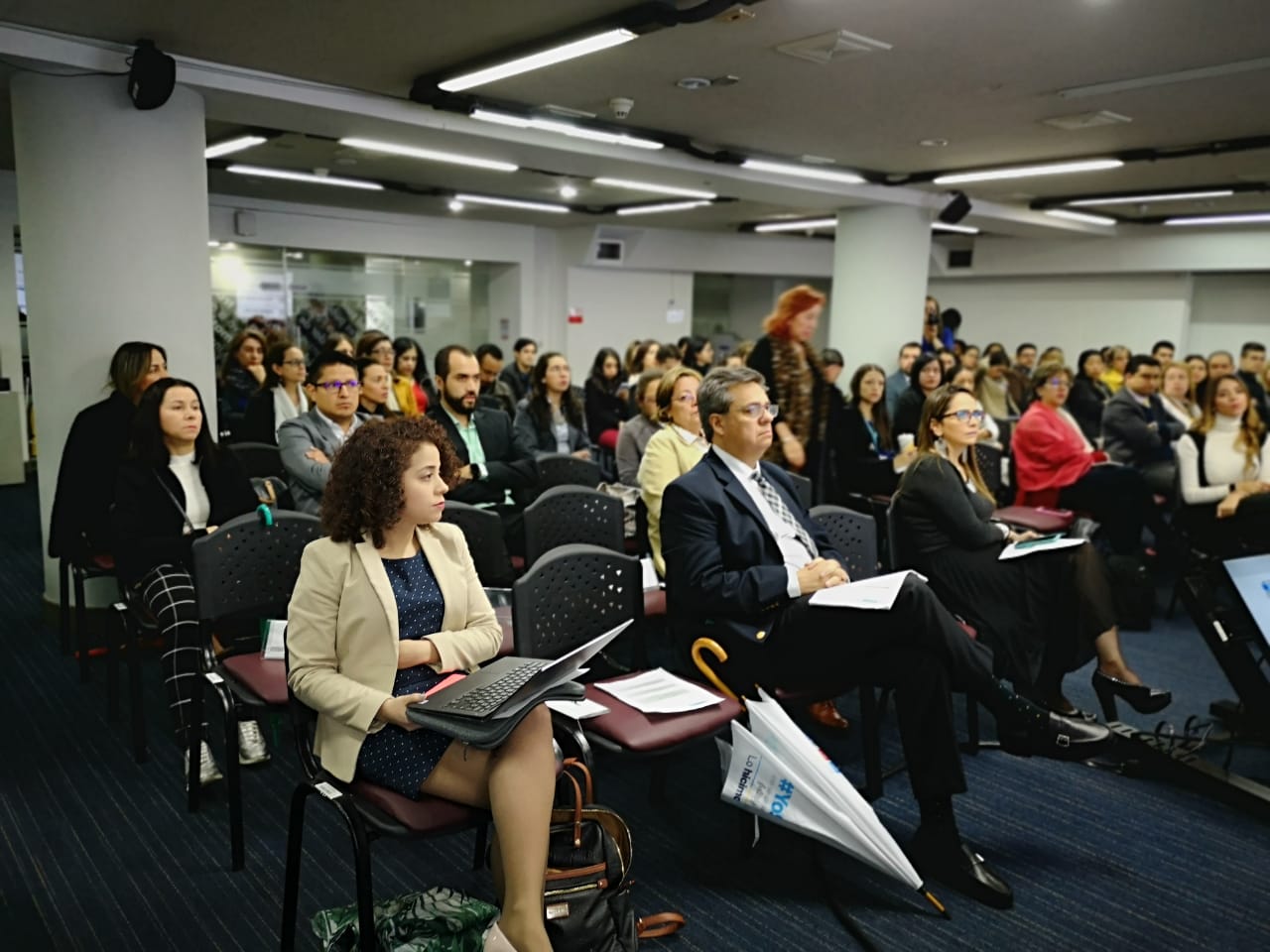 Personas sentadas en un auditorio presenciando el Encuentro del Equipo Transversal de Contratación