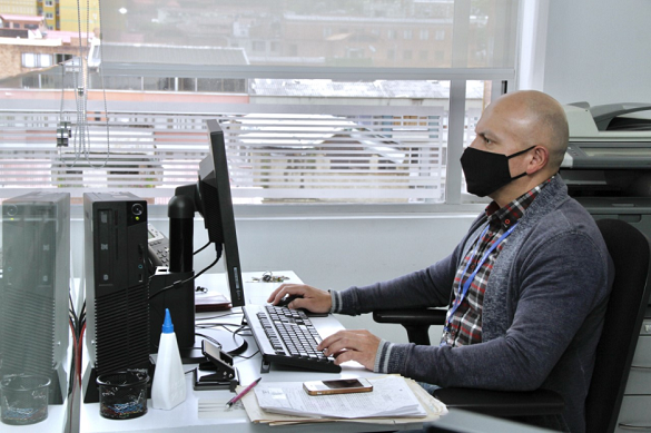 Hombre tecleando frente a un computador 