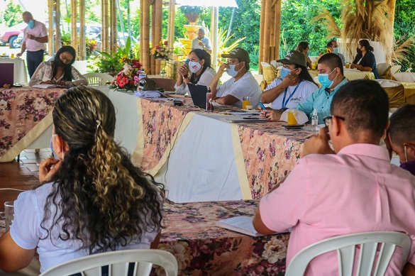 Aspecto de una reunión en territorio donde se ven varias personas sentadas en torno a una mesa