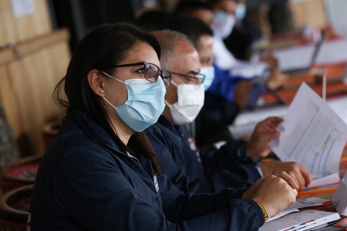 Grupo de personas con tapabocas, en  primer plano se observa a una mujer