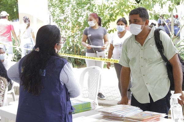 Mujer atiende a hombre con tapabocas