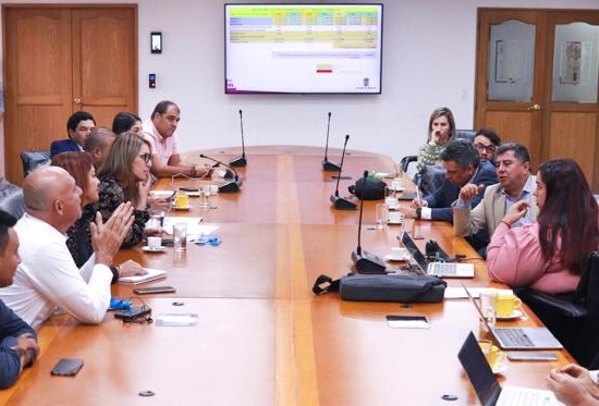 Hombres y mujeres sentados alrededor de una mesa en una reunión 