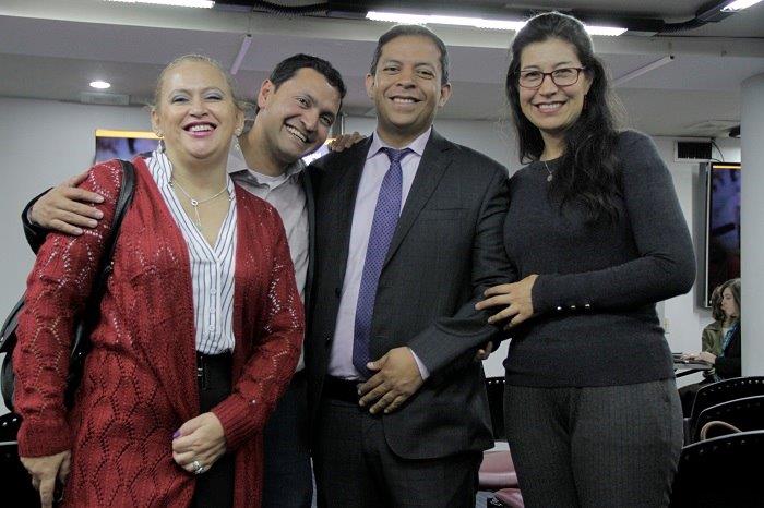 La imagen muestra a cuatro personas, 2 hombres, 2 mujeres, sonriendo mientras miran a la cámara