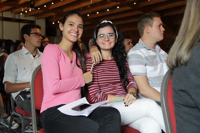 Dos mujeres jóvenes sentadas sonriendo a la cámara