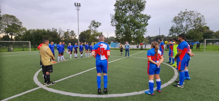 Dos equipos de fútbol formados al rededor de la parte central de la cancha