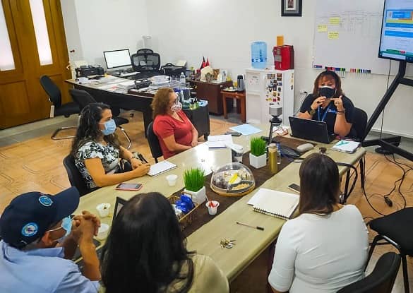 Grupo de mujeres sentadas alrededor de una mesa para juntas