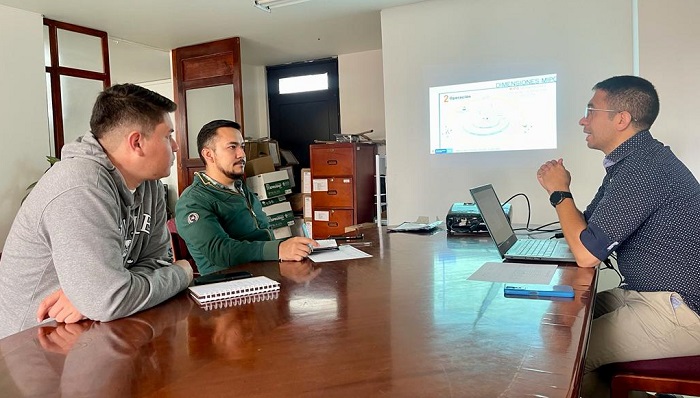 Tres hombres sentados en torno a una mesa de reuniones