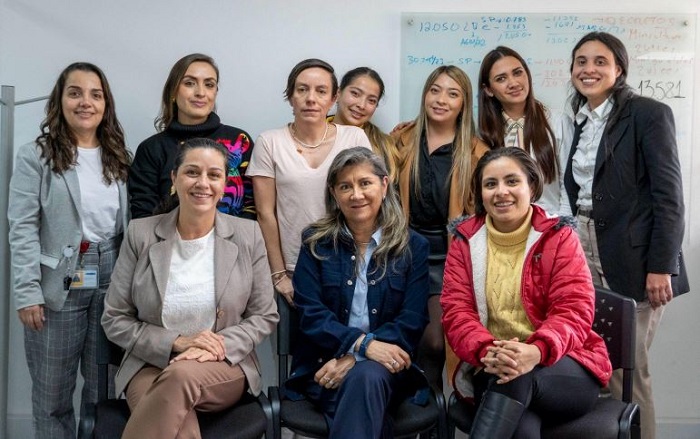 Un grupo de 10 mujeres, 7 de pie y 3 sentadas delante, sonrientes y mirando a la cámara