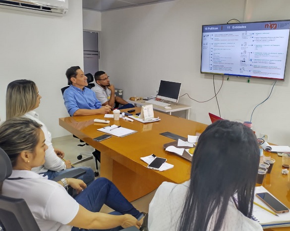 Personas en una reunión mirando a la pantalla de un televisor 