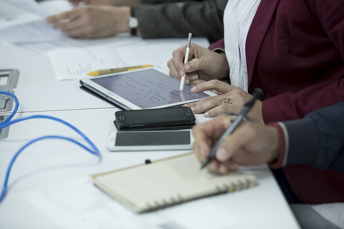 Imagen de las manos de personas trabajando en una tablet