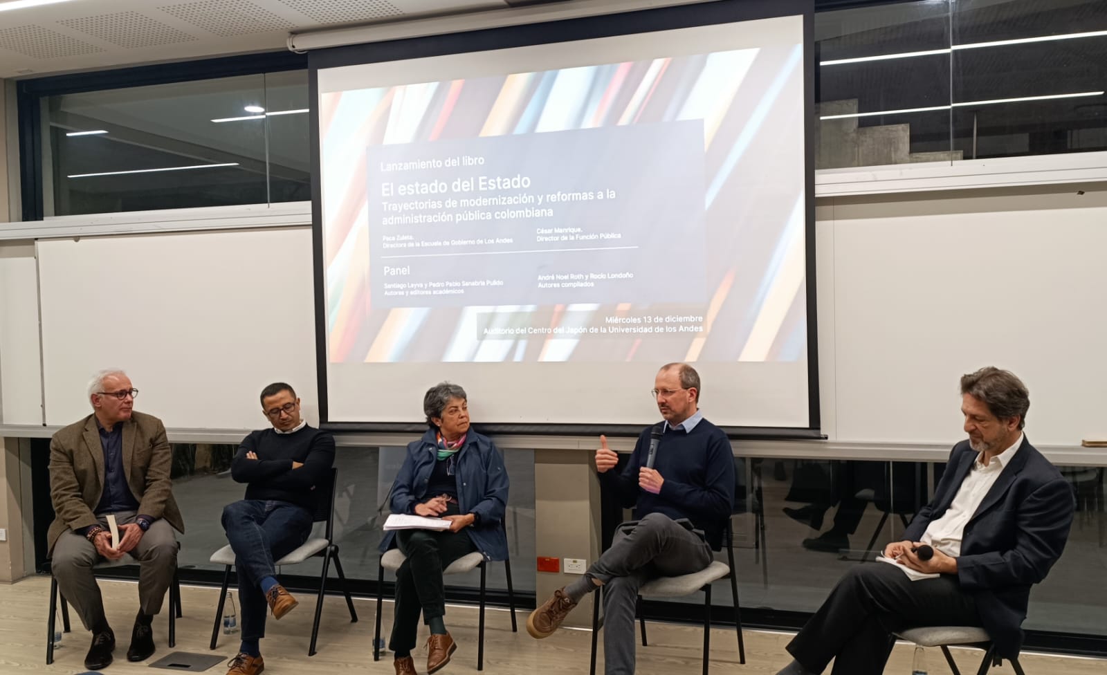 Personas hablando frente a un auditorio 
