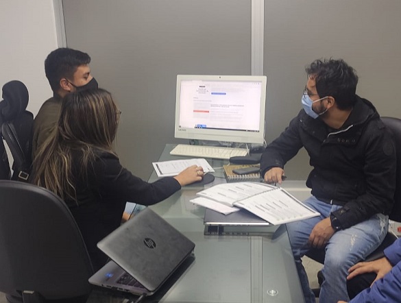 Tres personas mirando a un computador 