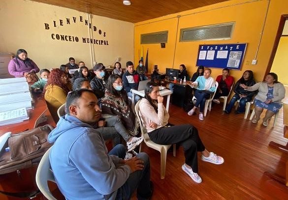 Grupo de personas numeroso sentadas dentro de un salón