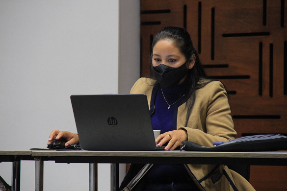 Mujer con tapabocas frente a un computador 